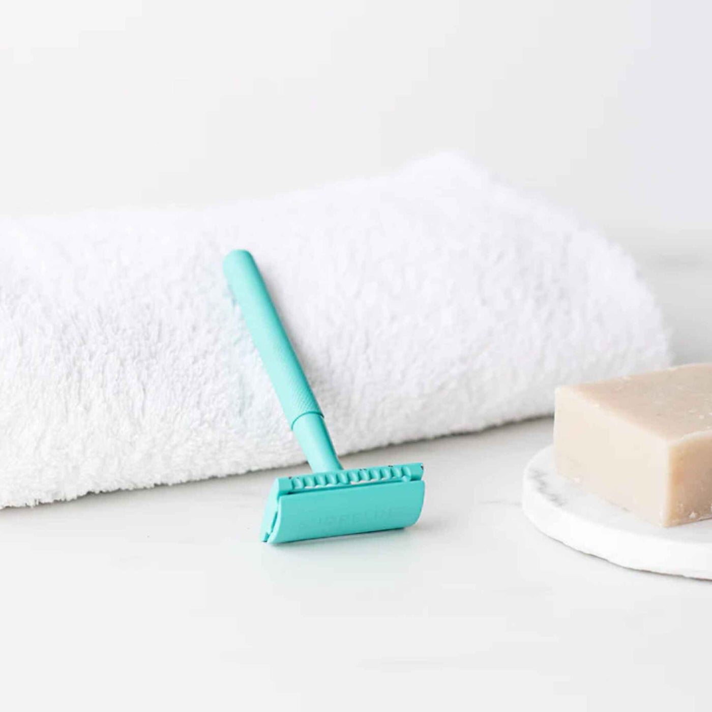 Safety Razor In Teal Lying On Side